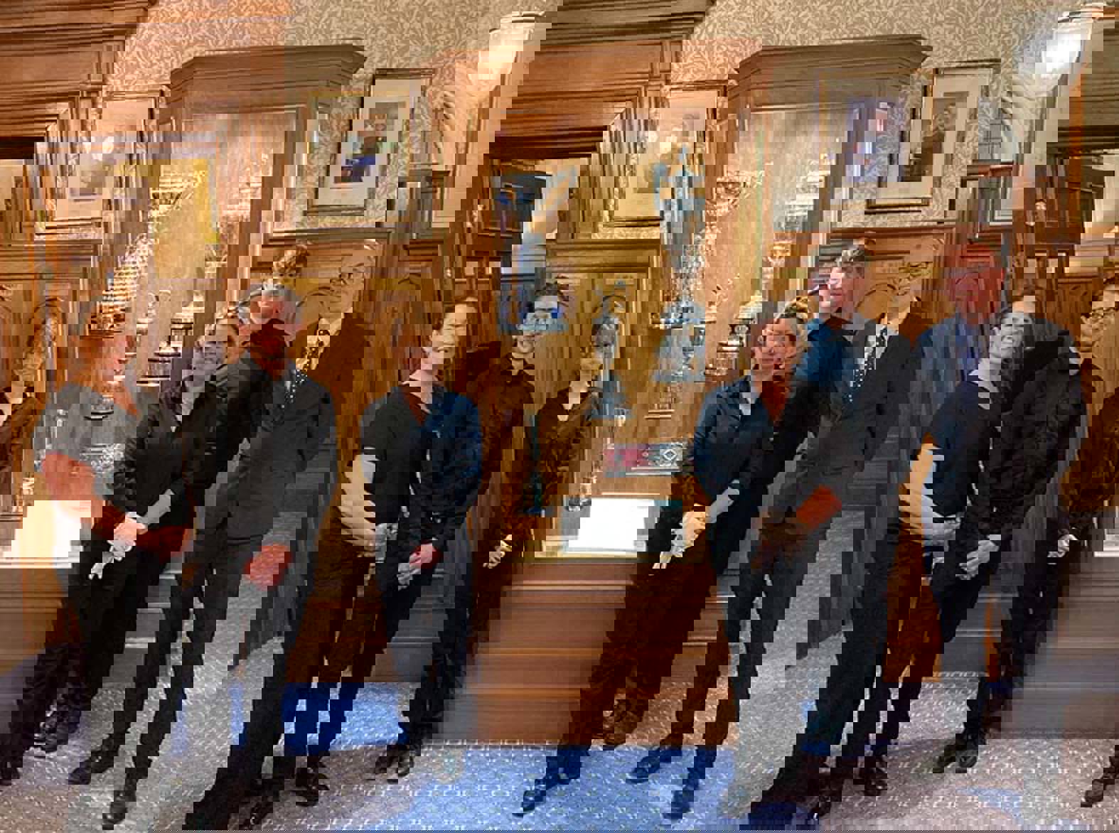 A group of people standing in front of a trophy cabinet