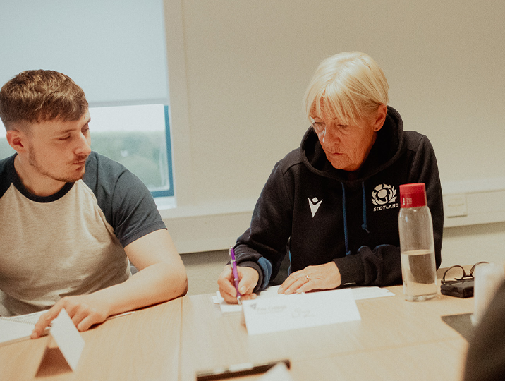 two project management students working at desk