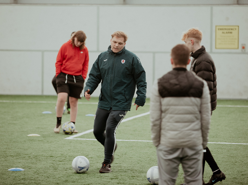 male sports students playing football