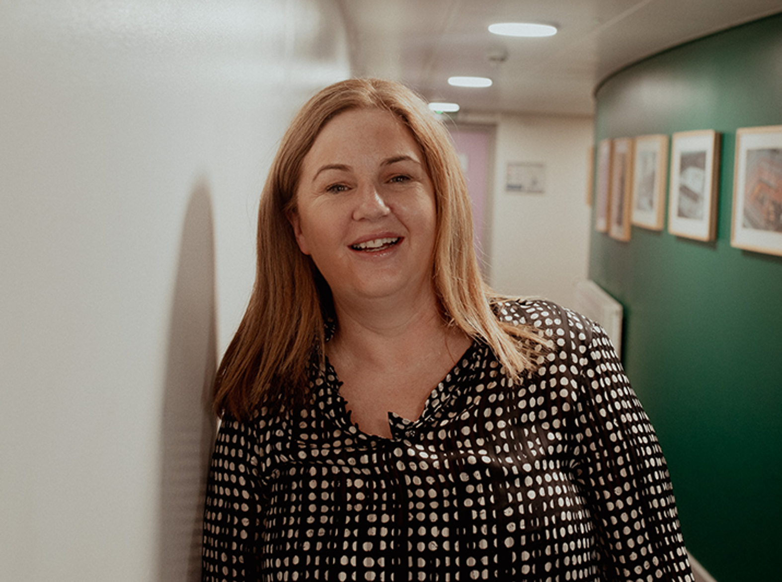 female student smiling at camera in corridor