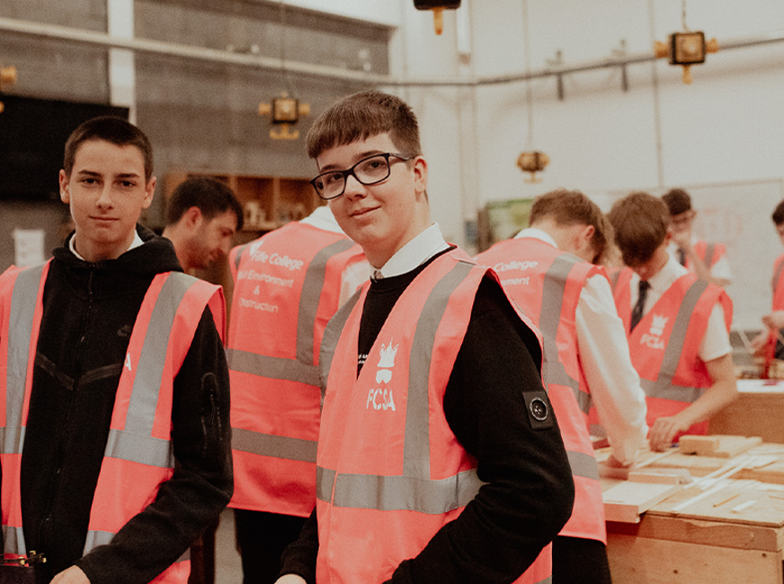 foundation apprenticeship students smiling at camera wearing high vis jackets