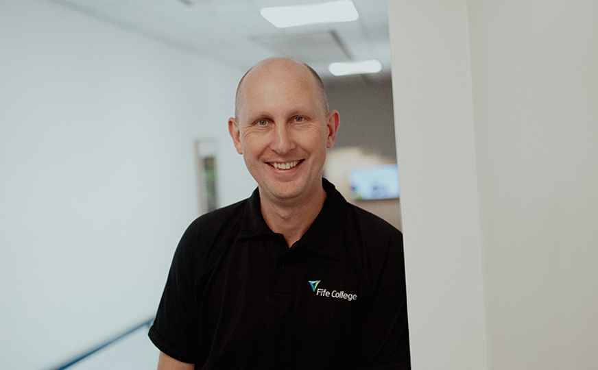 principal jim metcalfe smiling in hallway