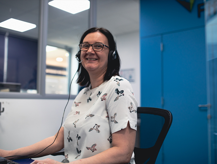 reception staff member smiling at camera wearing headset